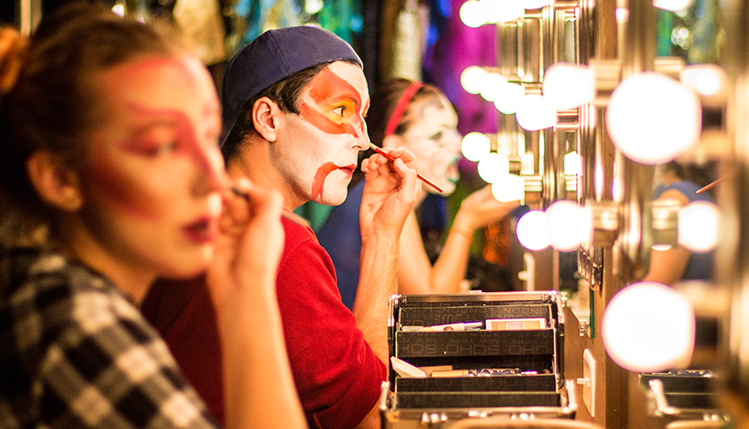 Theatre students applying makeup before a performance