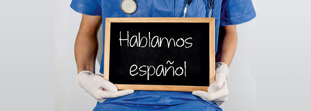 Doctor holding a sign saying Hablamos español, or 