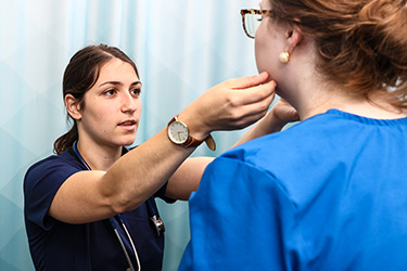 A nurse examines a patient